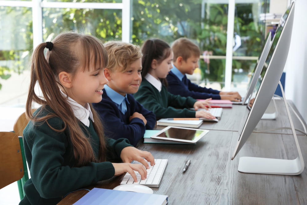 school children working on computers in classroom
