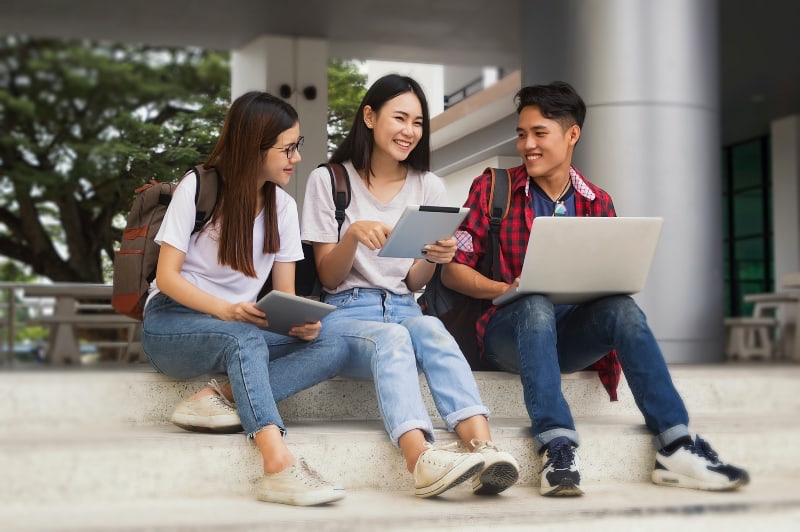 foreign students sitting on a step chatting